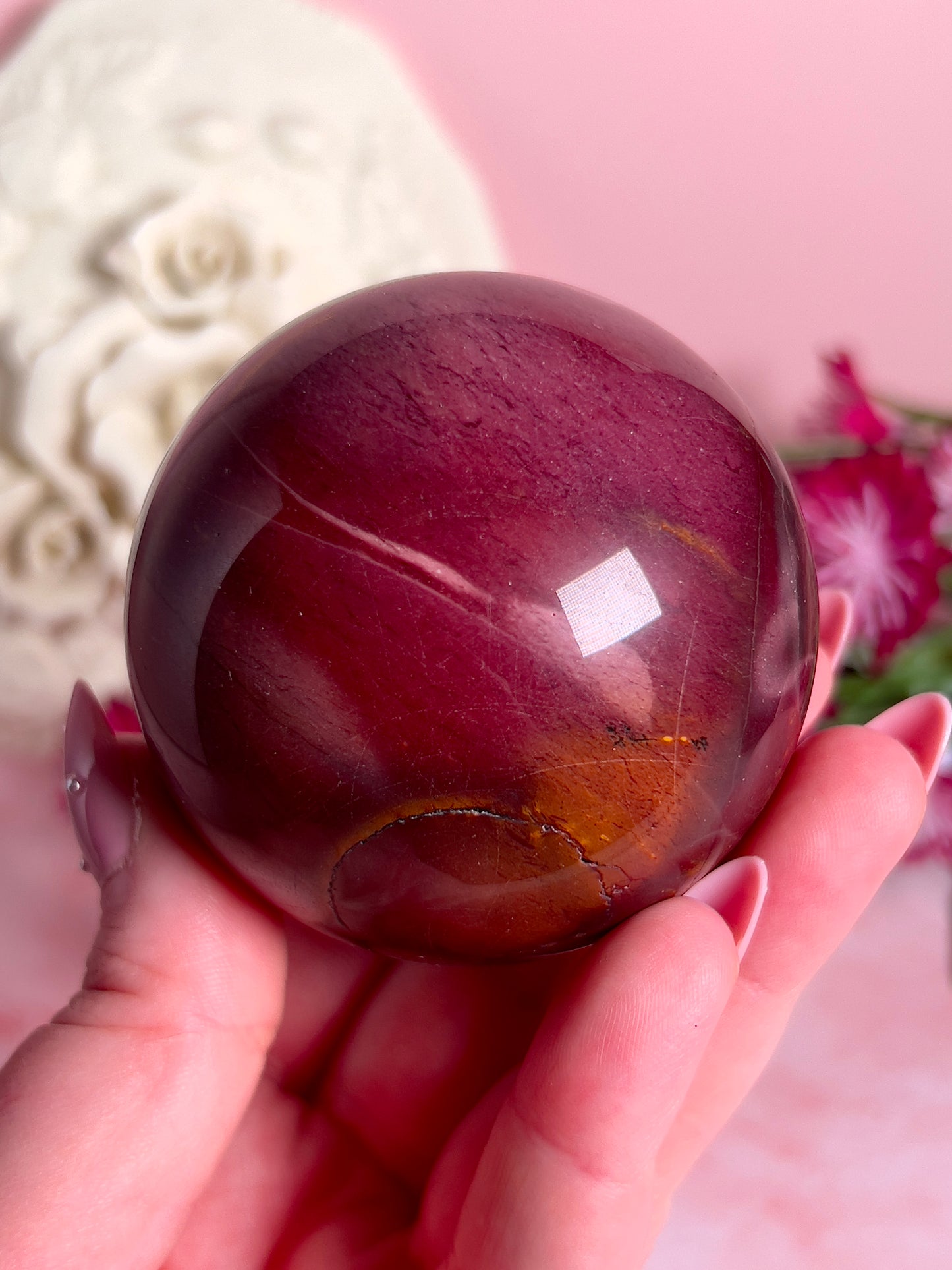 hand holding mookaite sphere