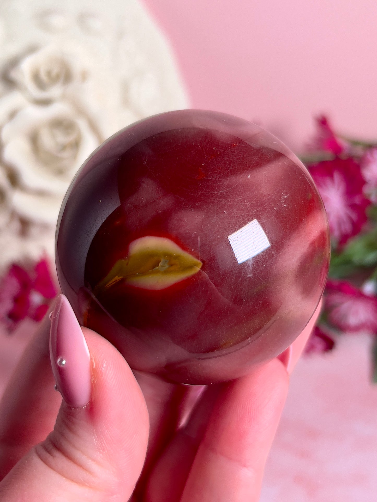 hand holding mookaite sphere
