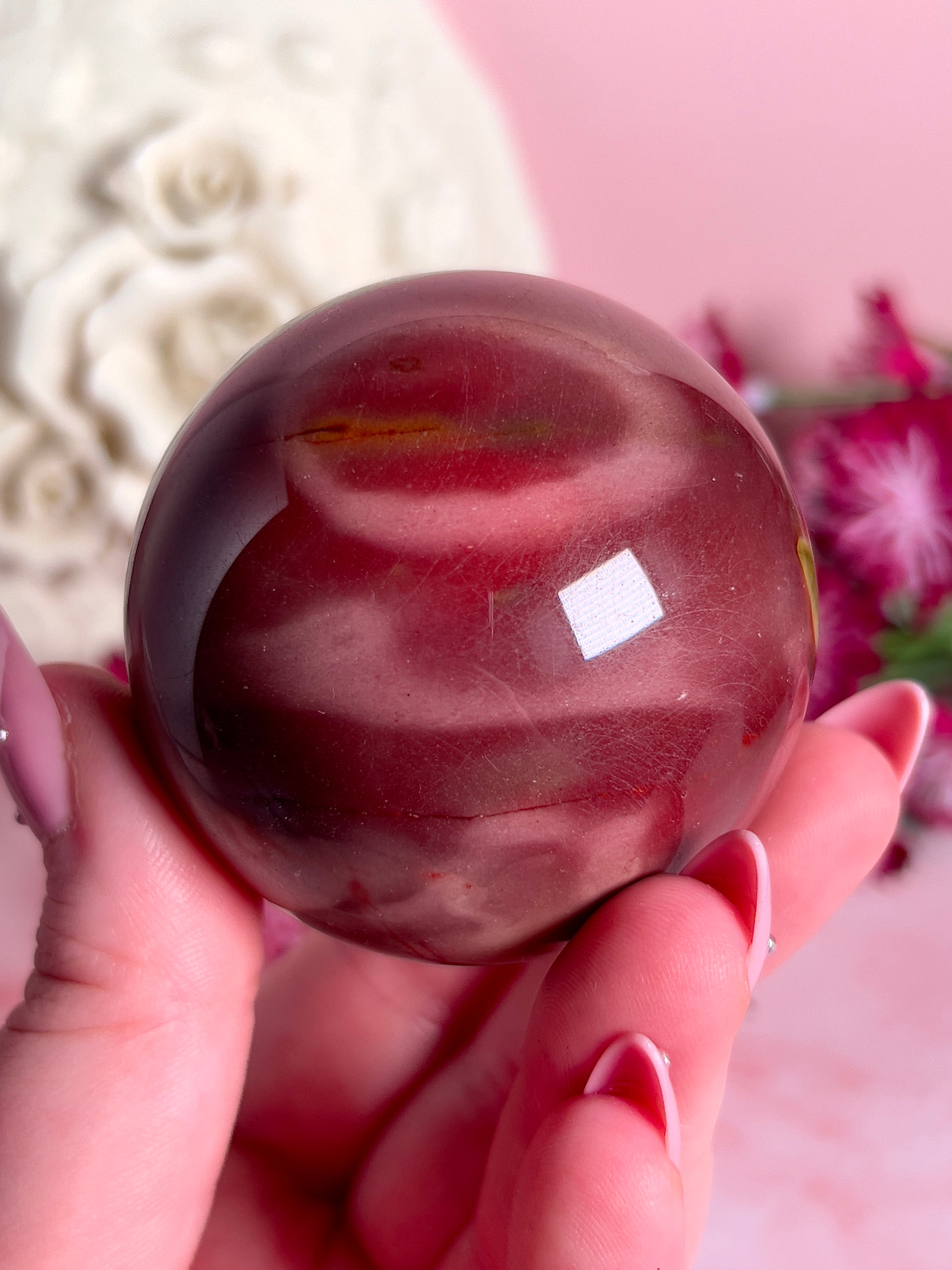 hand holding mookaite sphere