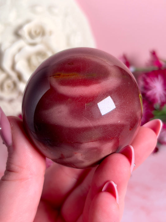 hand holding mookaite sphere