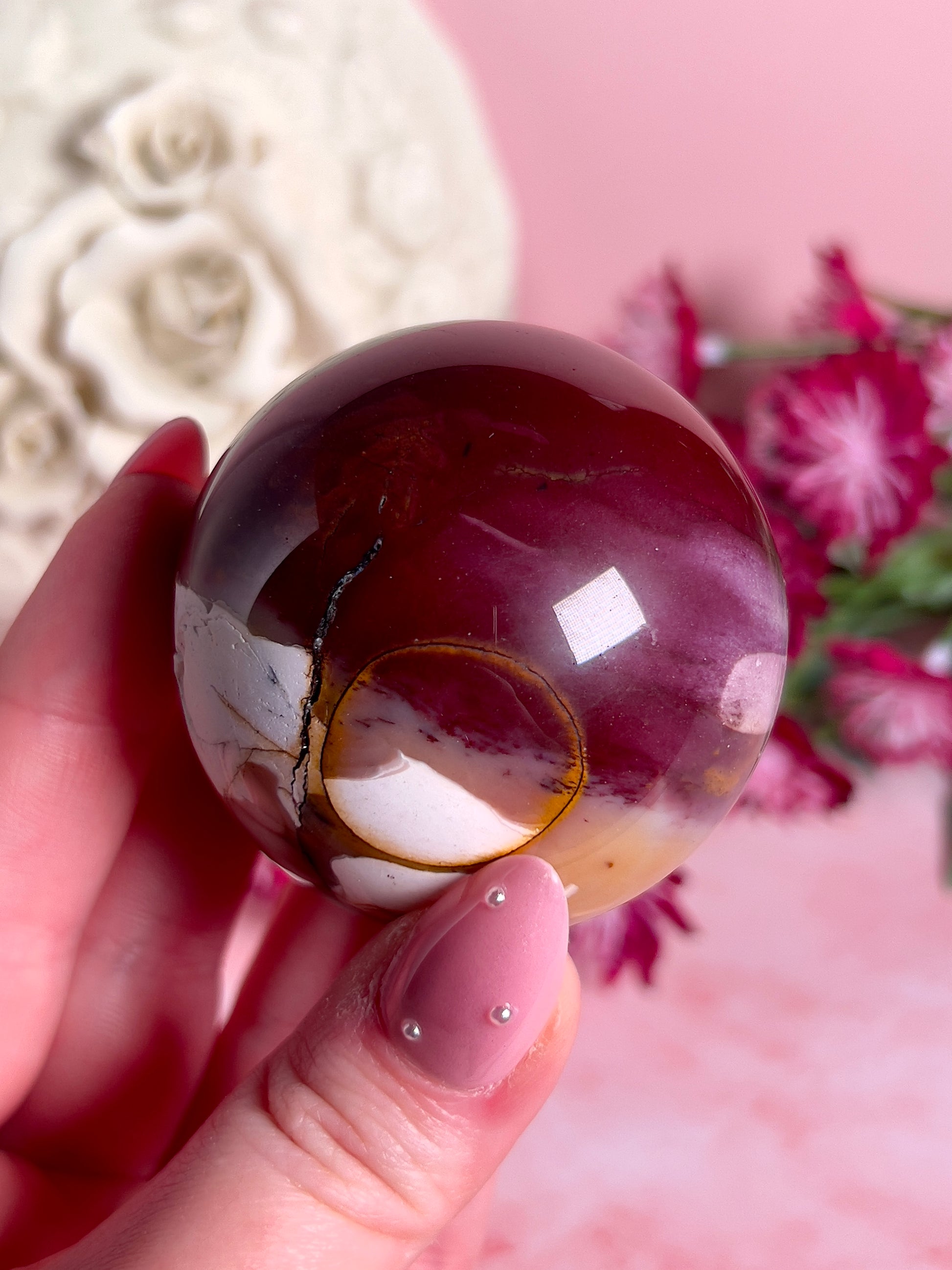 hand holding mookaite sphere