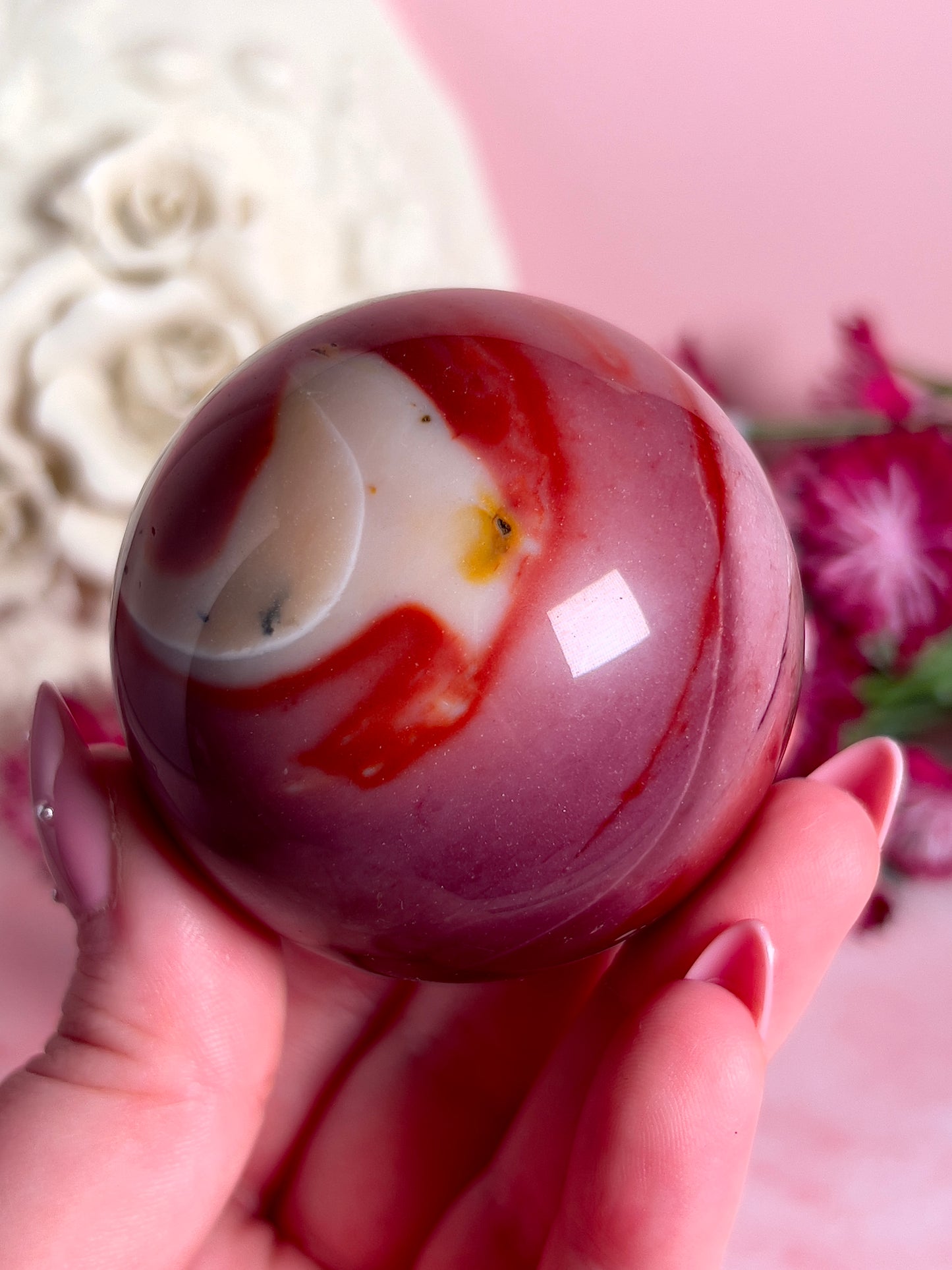 hand holding mookaite sphere