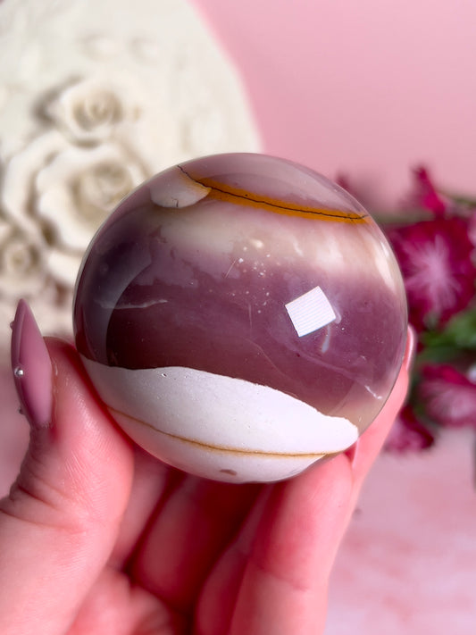 hand holding mookaite sphere