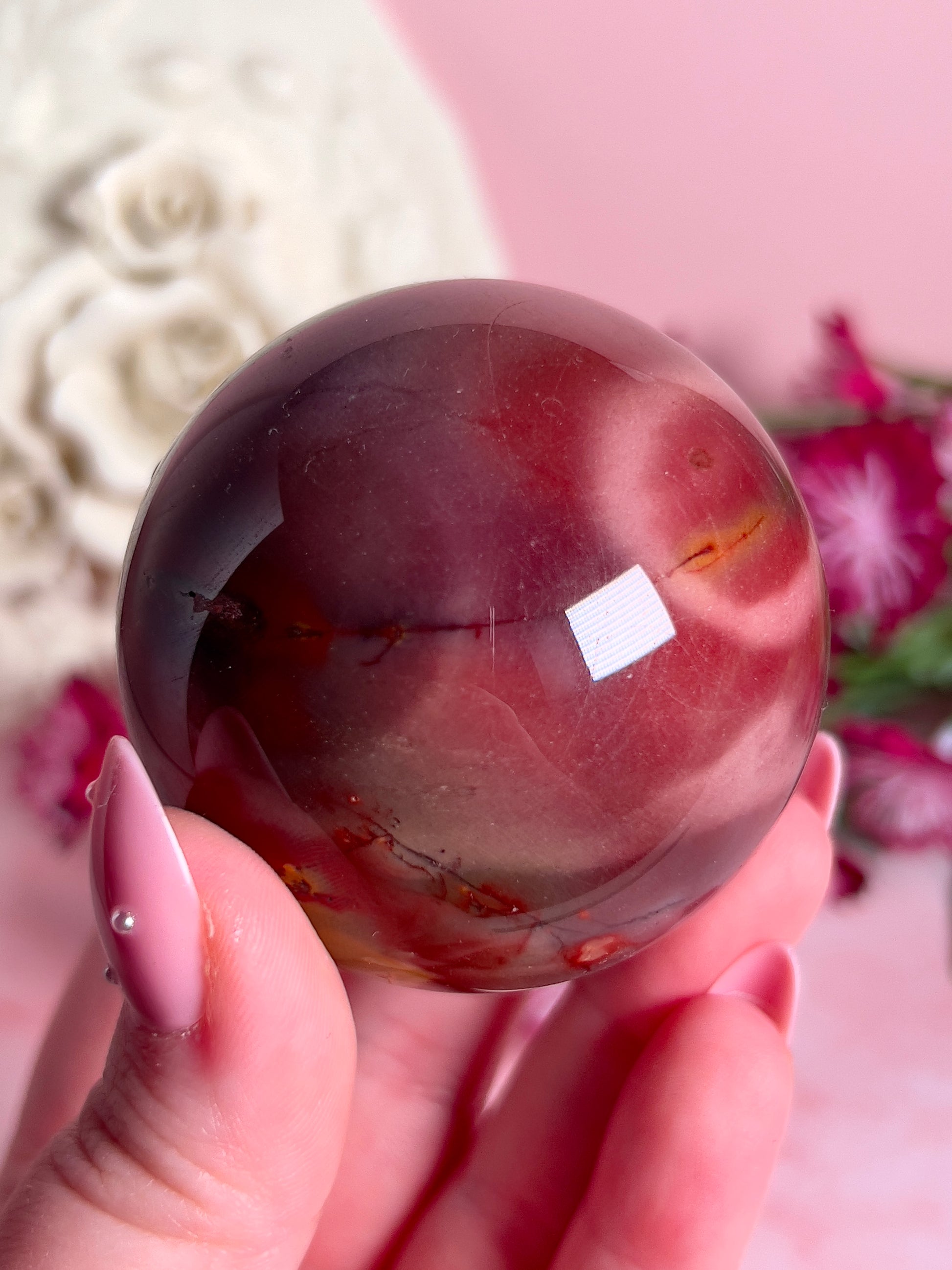 hand holding mookaite sphere