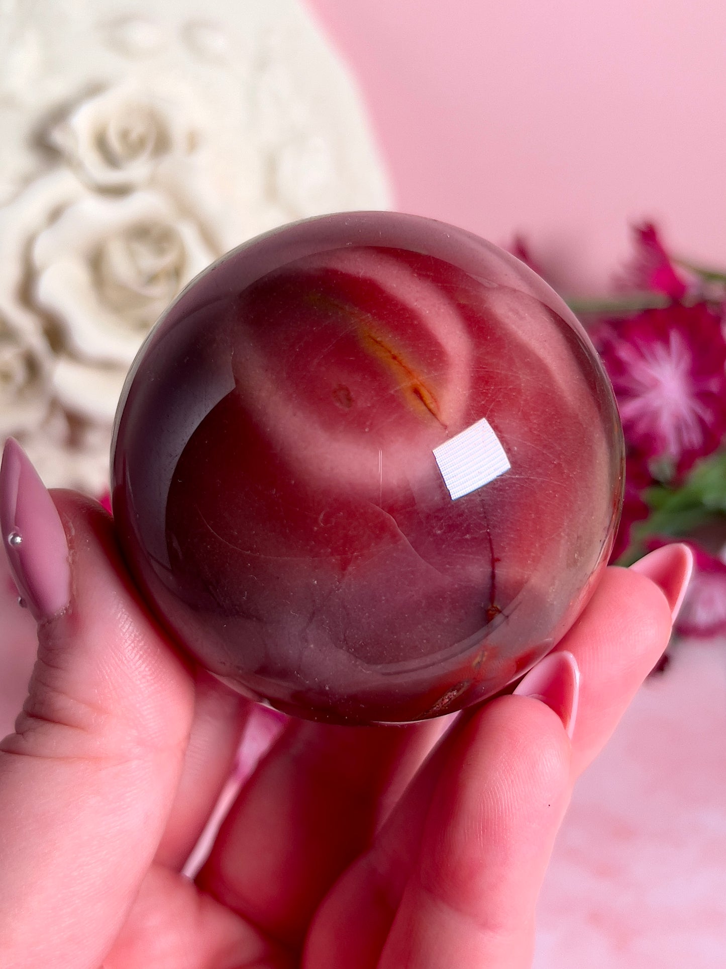 hand holding mookaite sphere