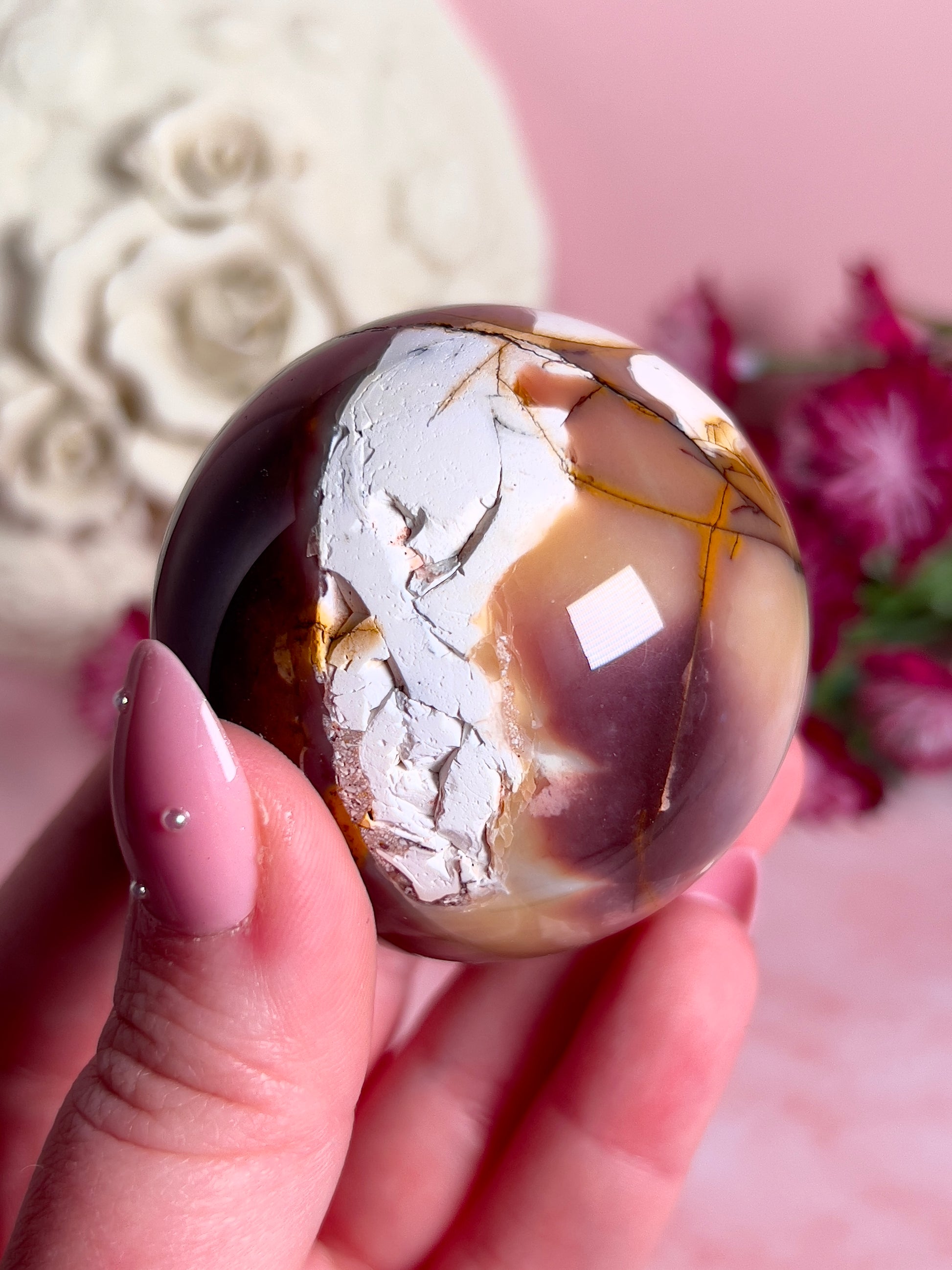 hand holding mookaite sphere