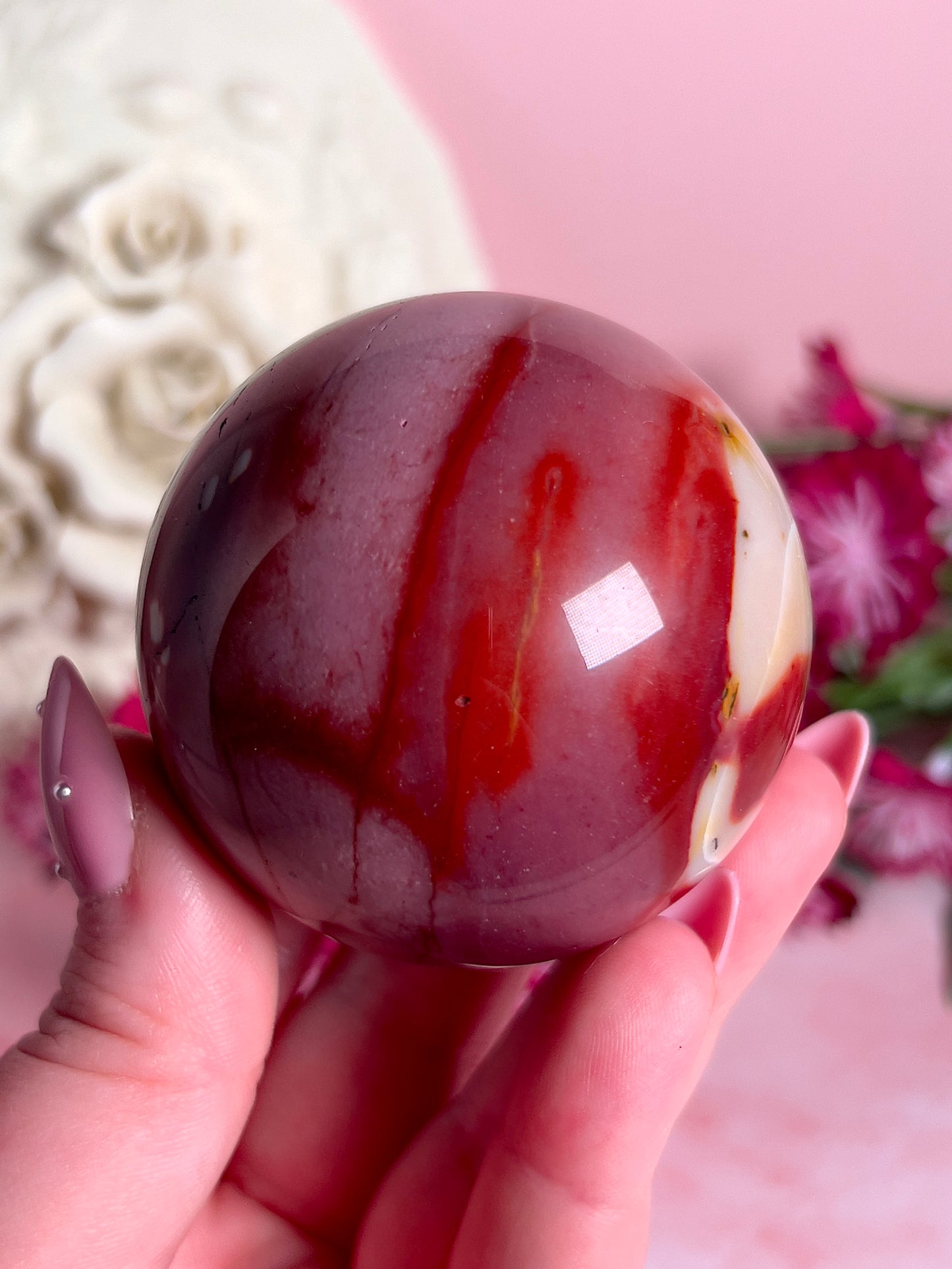 hand holding mookaite sphere