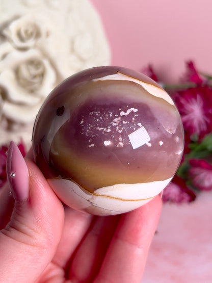 hand holding mookaite sphere