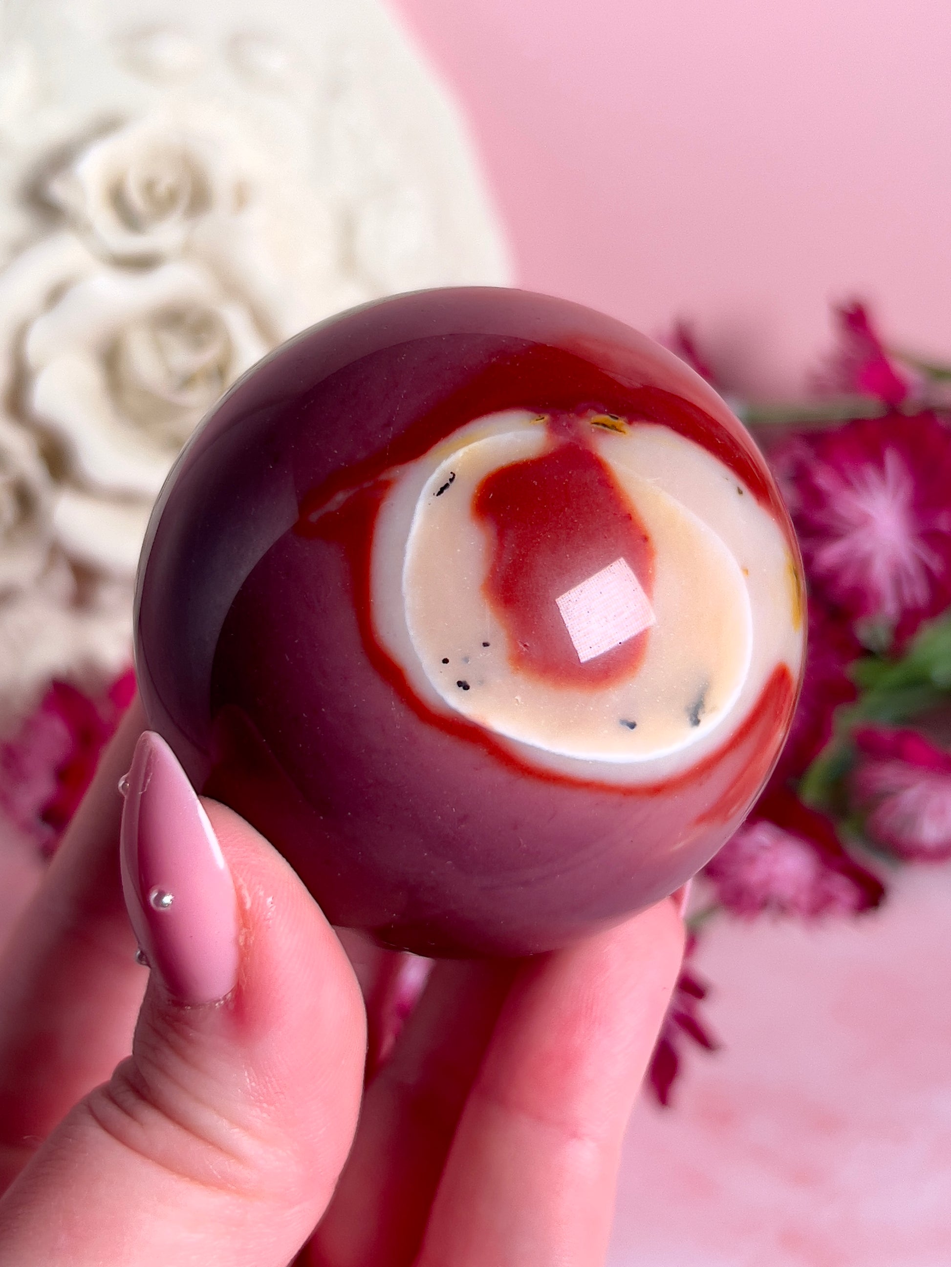 hand holding mookaite sphere