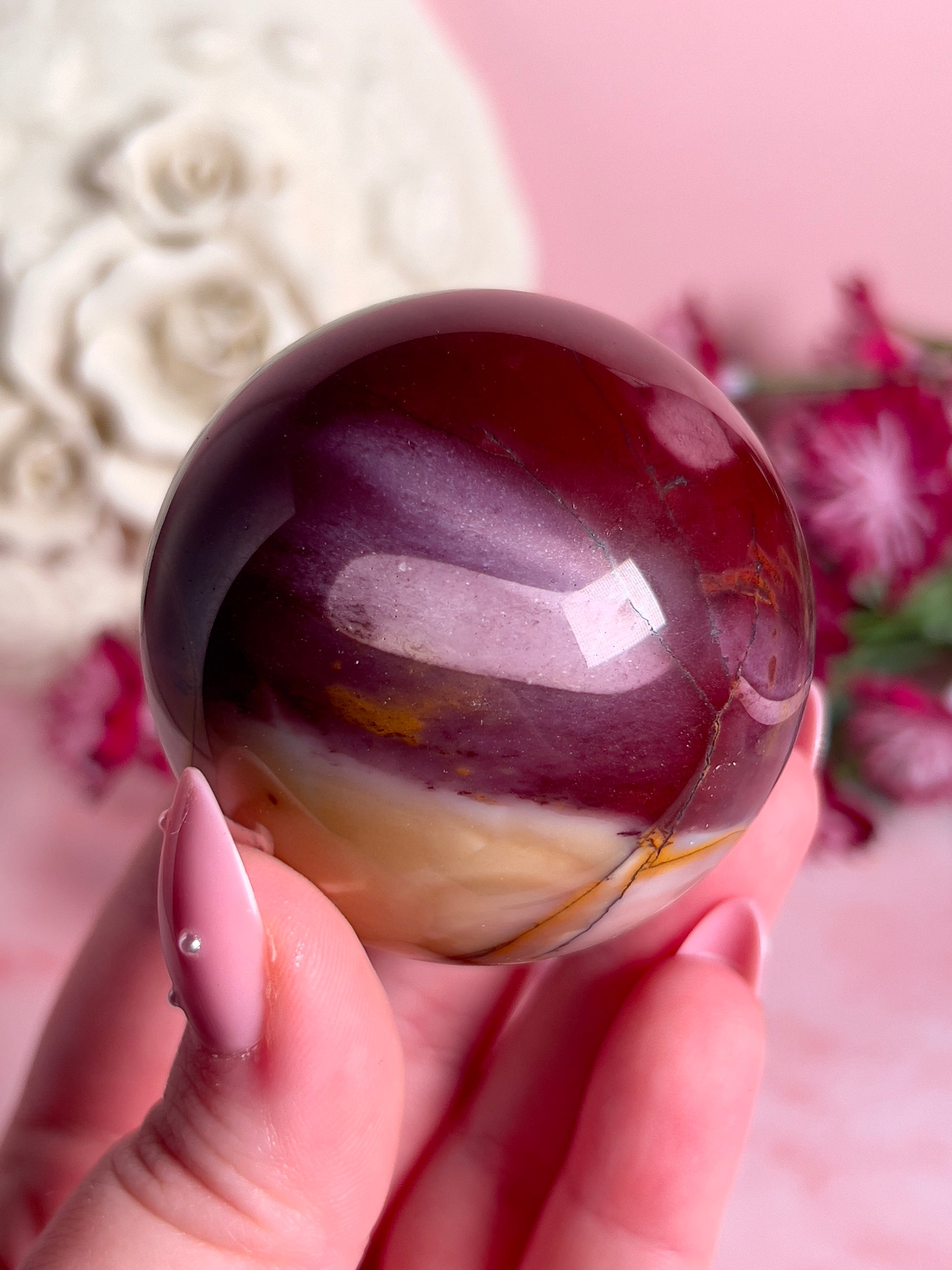 hand holding mookaite sphere