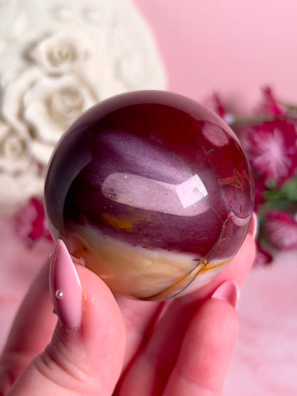 hand holding mookaite sphere