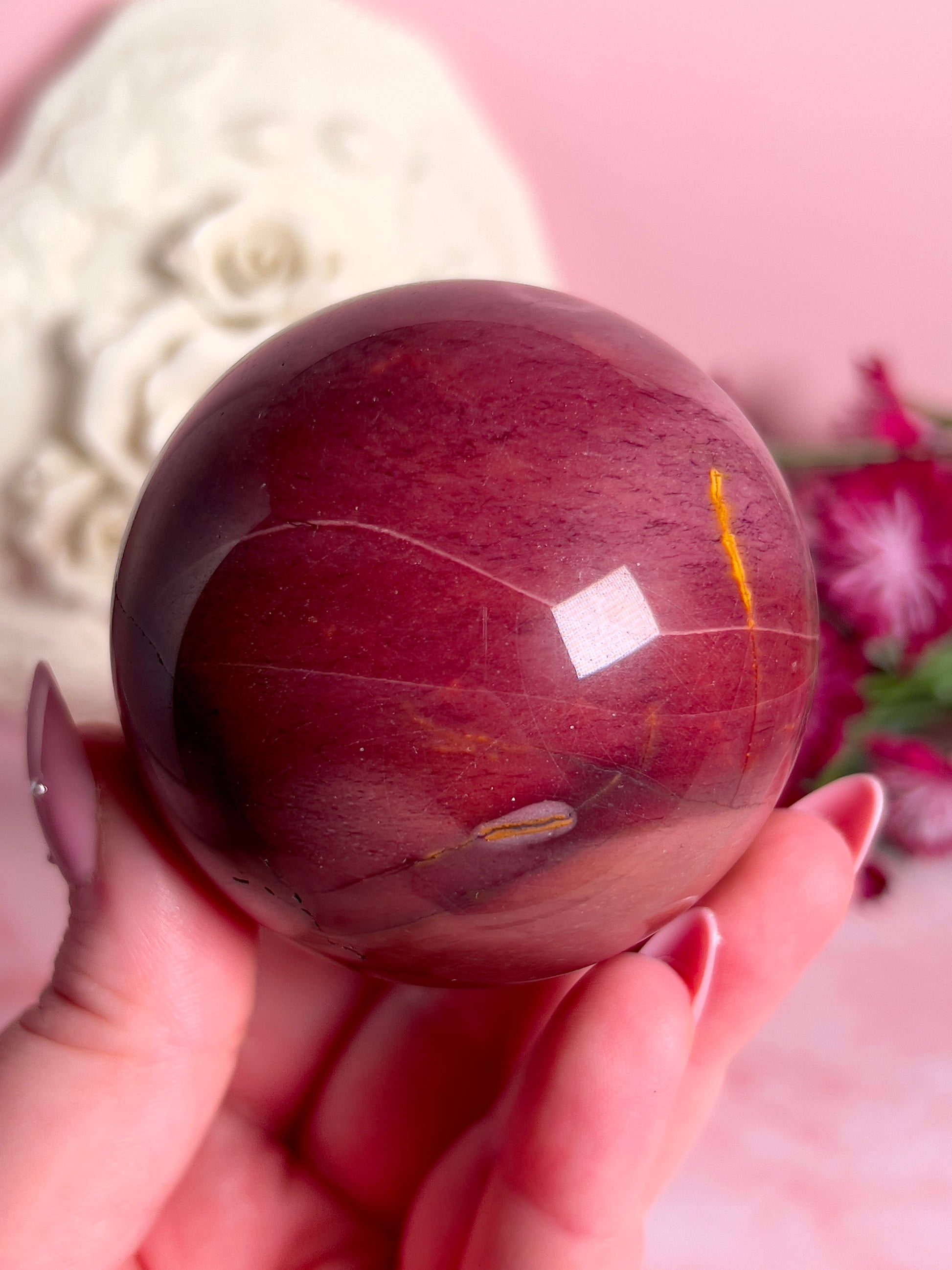 hand holding mookaite sphere