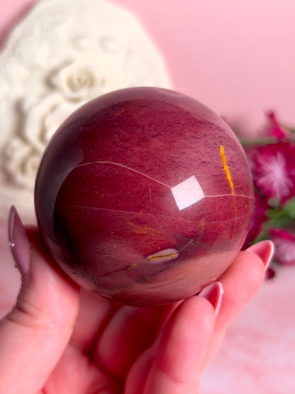 hand holding mookaite sphere
